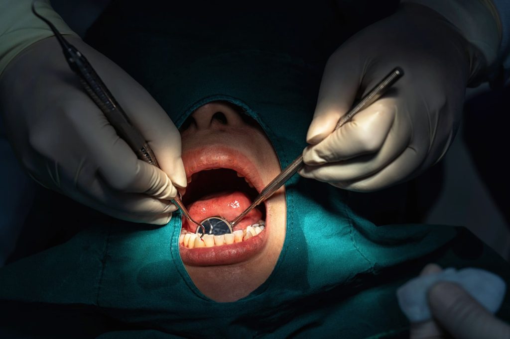 Dentist using a laser to treat gum disease, highlighting the benefits of laser therapy for gum disease at Dentistry With A Woman’s Touch in Toms River, NJ.