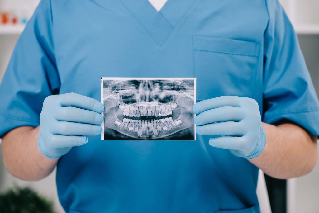 Dentist performing laser treatment for receding gums near me at Dentistry With A Woman’s Touch in Toms River, NJ. Call 732-838-9525 for expert care.
